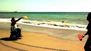 Paolo Badano che gioca a tennis sulla spiaggia: lasciando libere le mani, la carrozzina Genny consente ai disabili di praticare svariati sport