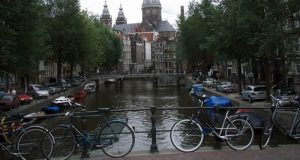 Amsterdam, biciclette parcheggiate lundo il corrimano di un ponte su un canale: la mobilità sostenibile è una delle chiavi per sconfiggere l'inquinamento (Foto cc: Joshua Doubek / Wikipedia)