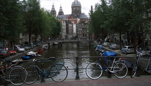 Amsterdam, biciclette parcheggiate lundo il corrimano di un ponte su un canale: la mobilità sostenibile è una delle chiavi per sconfiggere l'inquinamento (Foto cc: Joshua Doubek / Wikipedia)